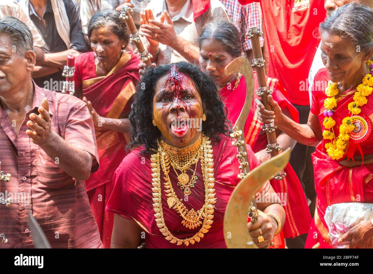 Anhänger im roten Kleid und Sickleshaped Schwerter am Sree Kurumba Sree Kurumba Bhagwati Tempel Kodungallur, während Bharani Festival, Thrissur, Kerala, Indien Stockfoto