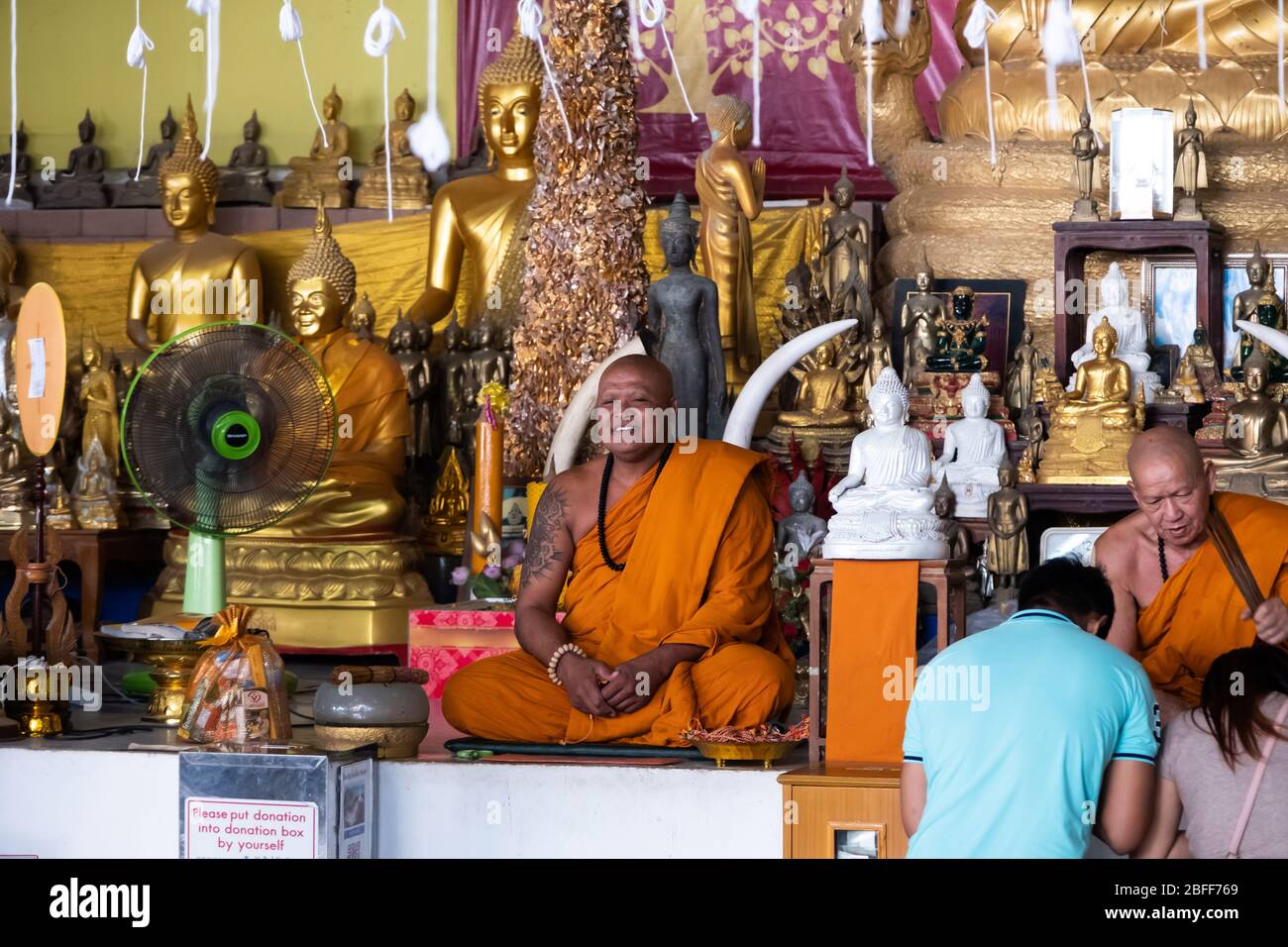 Großer Buddha Tempel, Phuket / Thailand - 19. Januar 2020: Zwei buddhistische Mönche weihen sich den Menschen Stockfoto