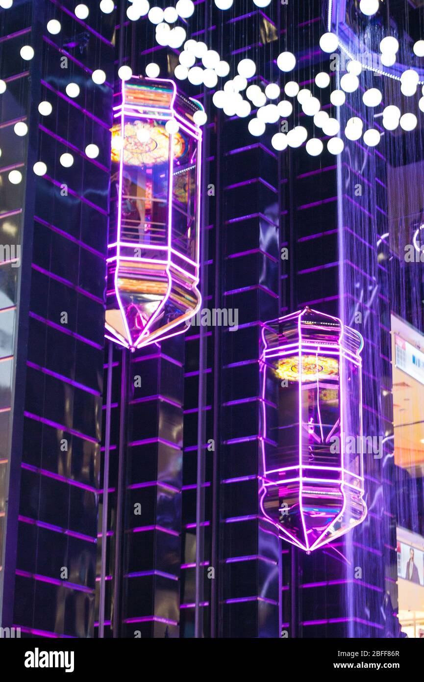Das Innenraumdesign des riesigen Stores ist die ursprüngliche Form von transparenten Glasaufzügen, die in fluoreszierenden Farben beleuchtet sind. Ausstrahlung, Bewegung, Unschärfe, surreal, märchenhaft, Schönheit, Licht, Beleuchtung, Farbe Stockfoto