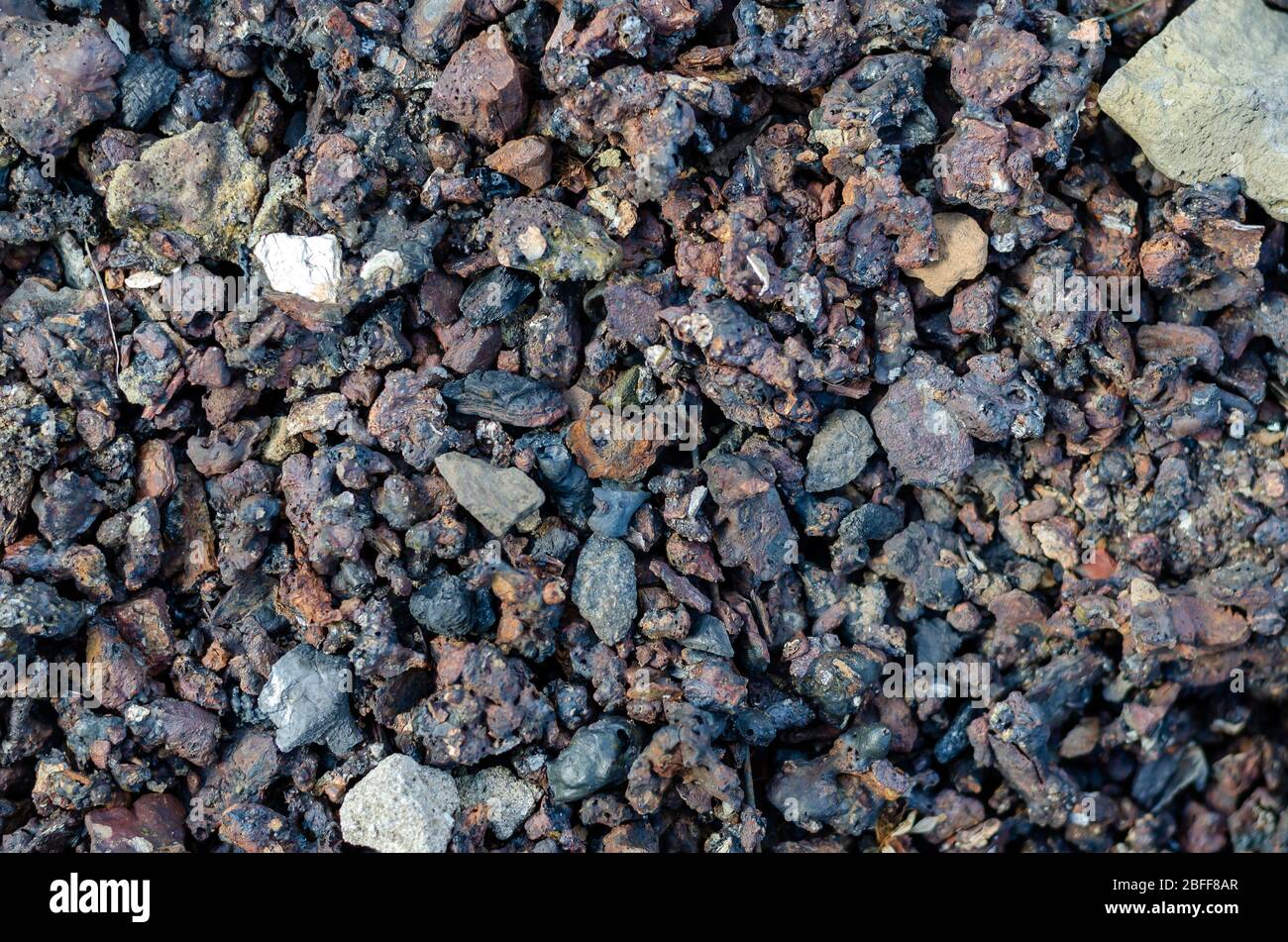 Schlacke aus verbrannter Kohle. Kohleasche Nahaufnahme. Kohle feste Rückstände Textur. Abstrakter Hintergrund für Multitasking. Selektiver Fokus. Stockfoto