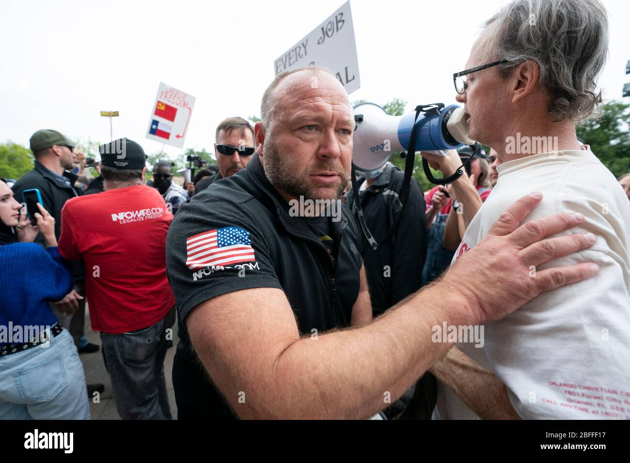 Alex Jones, Gründer der alt-right Infowars Website, arbeitet sich durch die Menge, als einige hundert Texaner sich über die sozialen Distanzierungsrichtlinien während einer 'You Can't Close America'-Rallye, die von der Website angeregt wird, hinwegtun. Kundgebung im Texas Capitol in Austin. Stockfoto