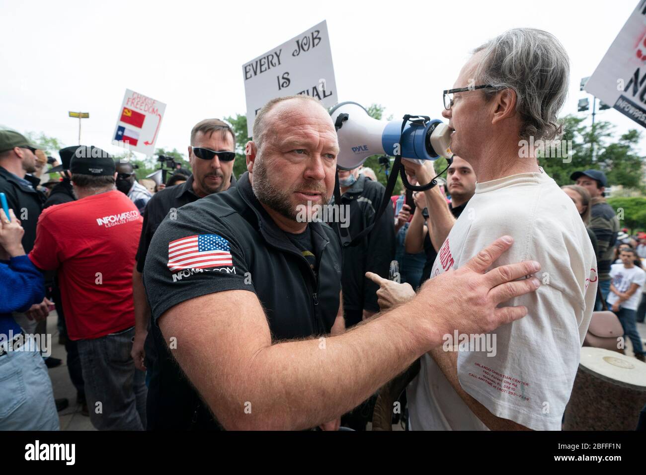 Alex Jones, Gründer der alt-right Infowars Website, arbeitet sich durch die Menge, als einige hundert Texaner sich über die sozialen Distanzierungsrichtlinien während einer 'You Can't Close America'-Rallye, die von der Website angeregt wird, hinwegtun. Kundgebung im Texas Capitol in Austin. Stockfoto