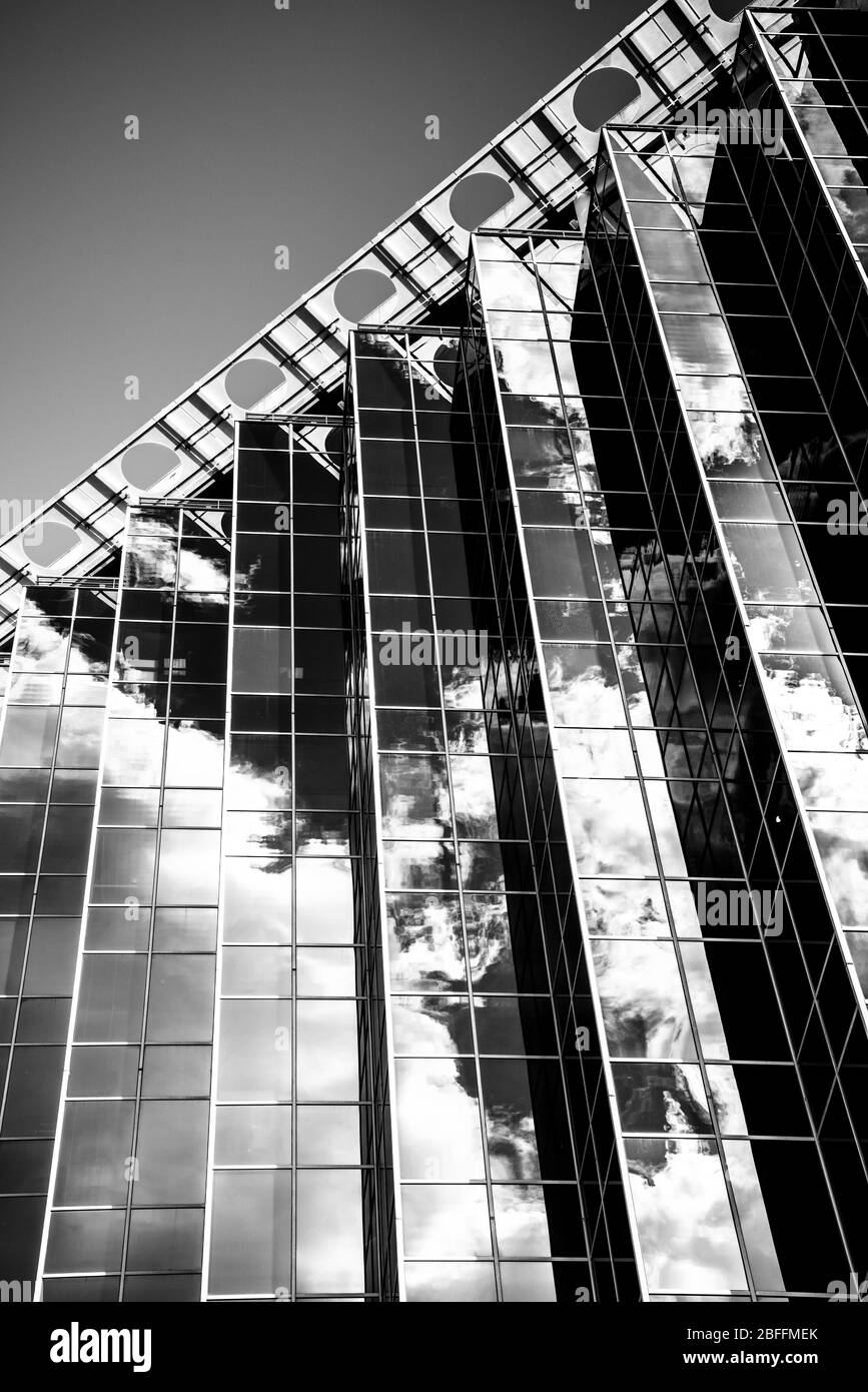 Modernes Hochhaus in San Antonio, Texas, mit Spiegelfassaden, die Himmel und Wolken reflektieren. Schwarz und Weiß, vertikale Ausrichtung Stockfoto