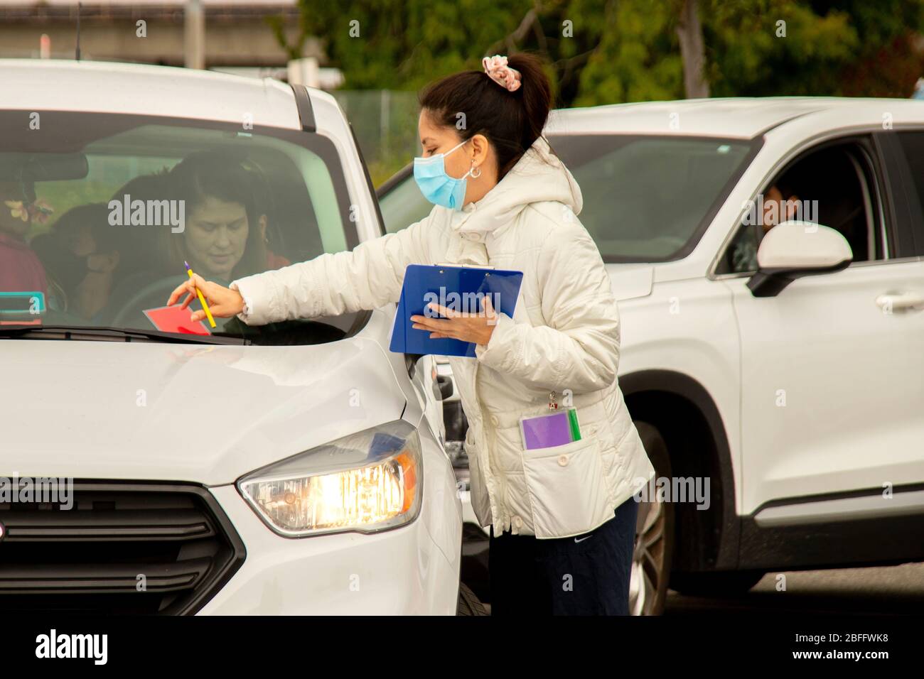 Eine Krankenschwester trägt eine Sicherheitsmaske und erfasst Daten von Patienten in einer Bluttesteinrichtung in einem Einkaufszentrum in Westminster, CA, für Coronavirus oder COVID-19. Stockfoto
