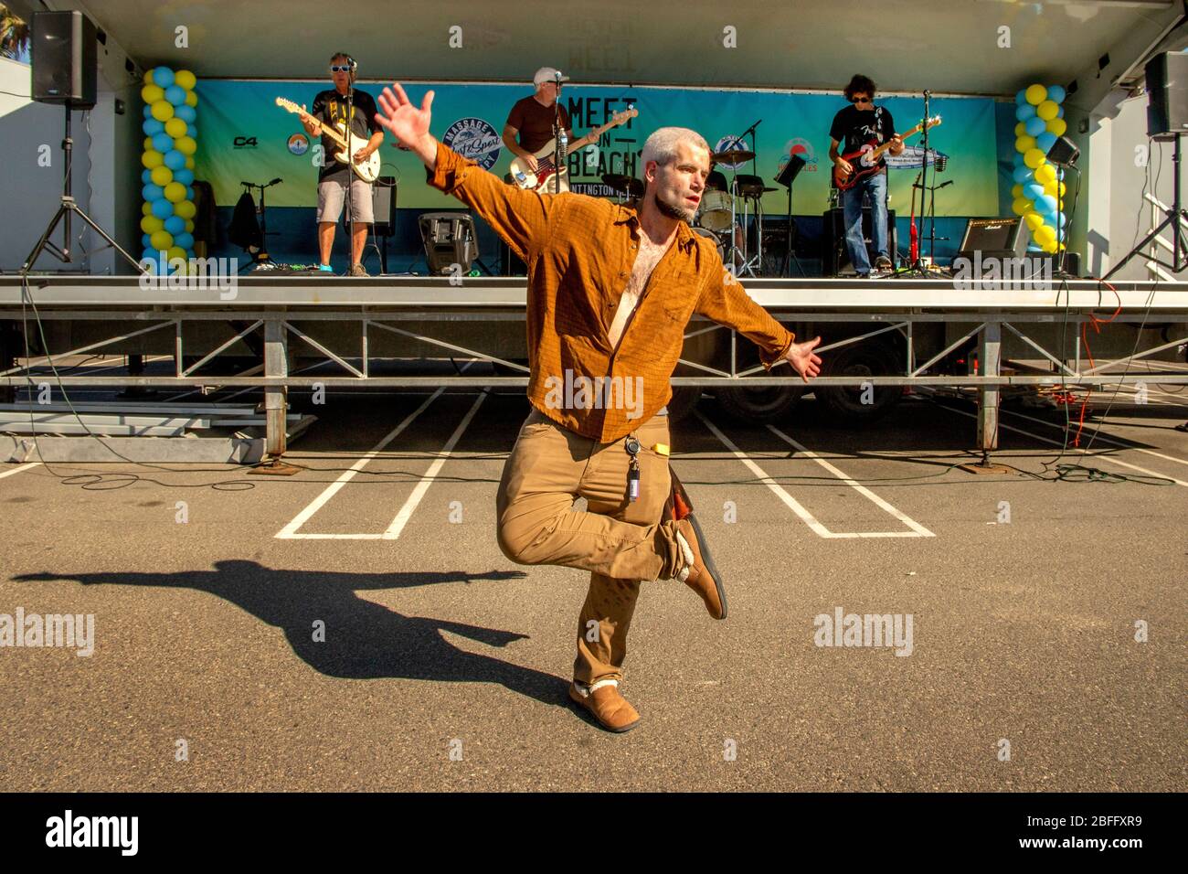 Ein Straßenkünstler tanzt spontan zur Musik einer Band, die bei einem Outdoor-Festival in Huntington Beach, CA auftrat. Stockfoto