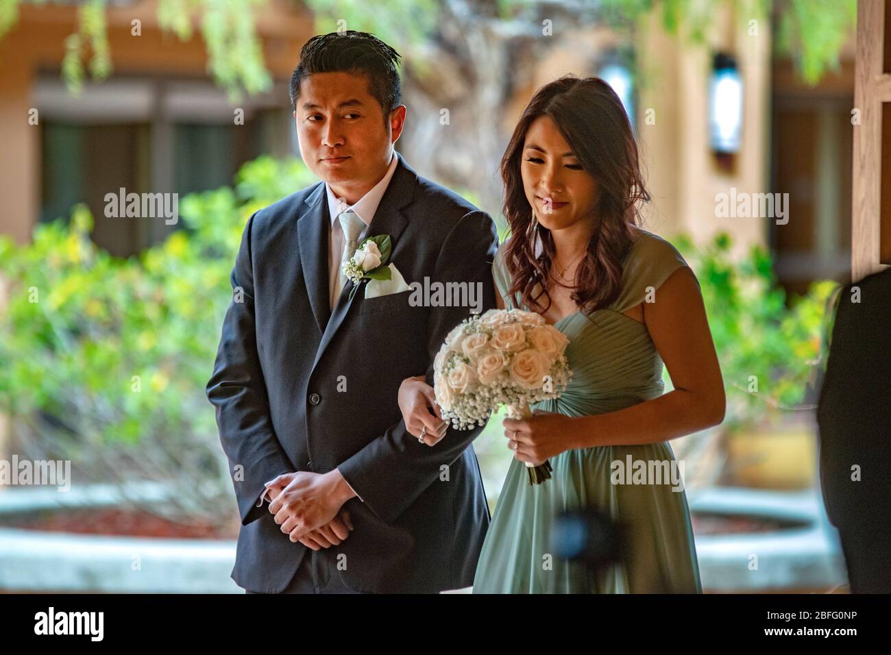 Ein vietnamesisches amerikanisches Gastpaar kommt zu einer Hochzeit in einer katholischen Kirche in Südkalifornien. Stockfoto