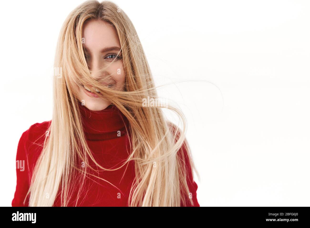 Beauty, Frauen und Mode Konzept. Portrait von attraktiven jungen Frau mit schönen langen Haaren in der Luft schweben, lächeln an der Kamera, promo der Haarpflege Stockfoto