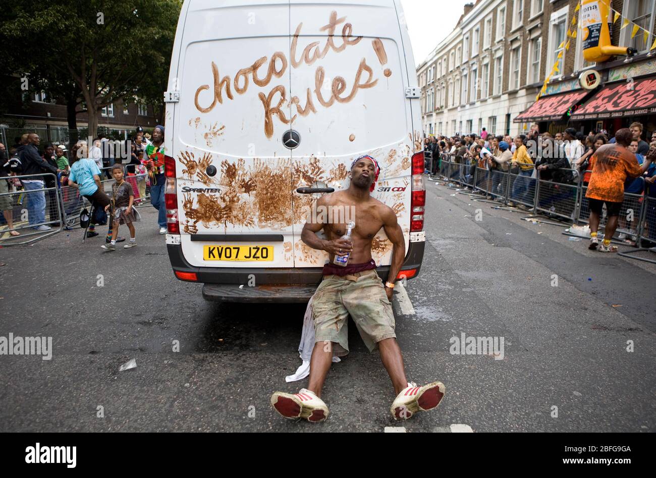 Während des Notting Hill Carnival in London decken Tänzer einen weißen Van mit Schokolade ab Stockfoto