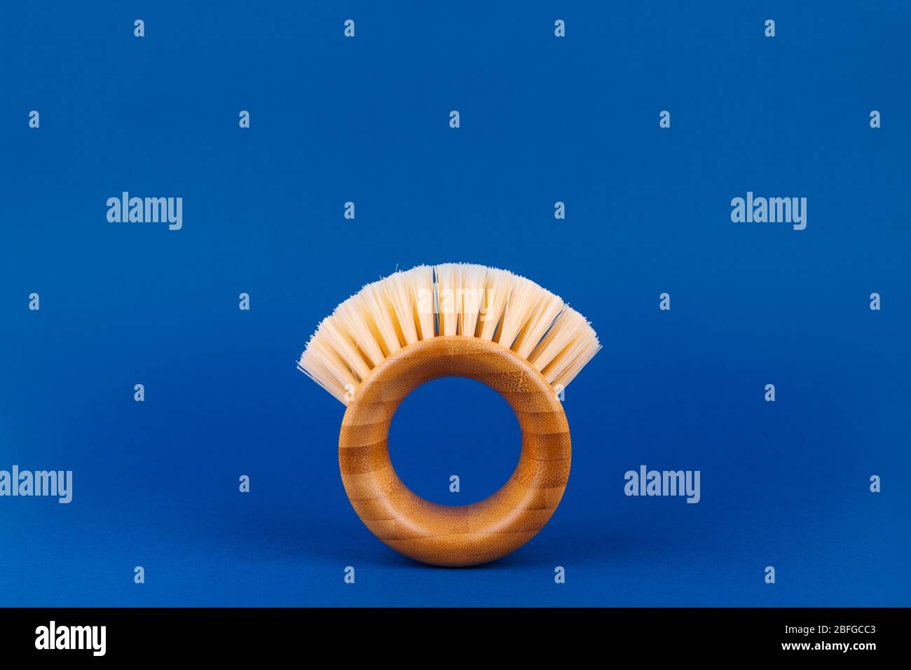 Moderne futuristische runde Bambusbürste für Obst und Gemüse auf klassischem Blau. Sicheres Reinigungs- und Bio-Produkt-Konzept. Copyspace, einfach auf Banner zugeschnitten Stockfoto