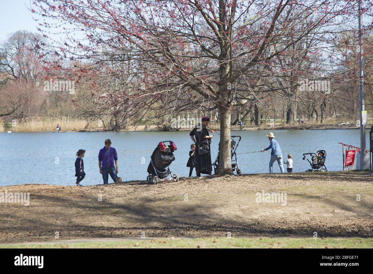 Während der Coronavirus-Pandemie in Brooklyn, New York, praktizieren die Menschen soziale Distanz entlang des Sees im Prospect Park. Stockfoto