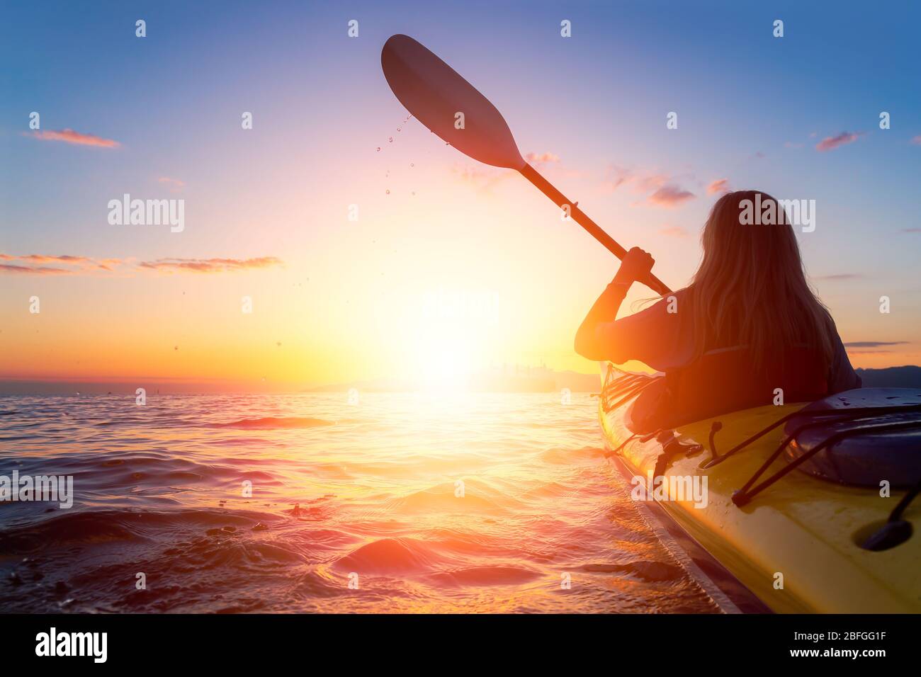 Frau auf dem Kajak paddelt im Meer Stockfoto