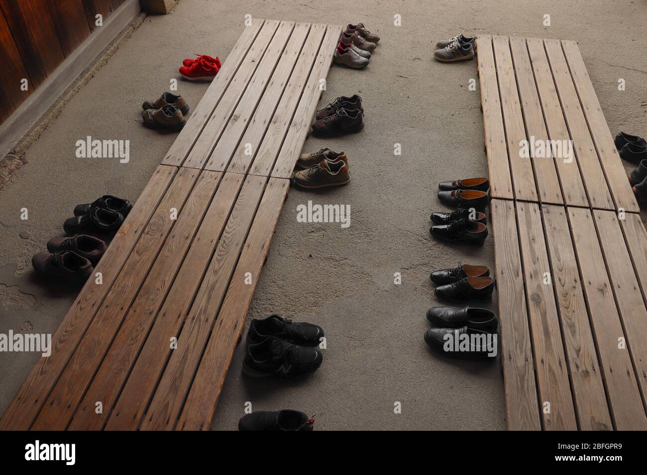 Viele Paar Schuhe in einem genkan, ein Ort, um auszuziehen oder ziehen Sie Ihre Schuhe, wie es der Brauch in Japan vor dem Betreten eines Hauses oder Museum. Stockfoto