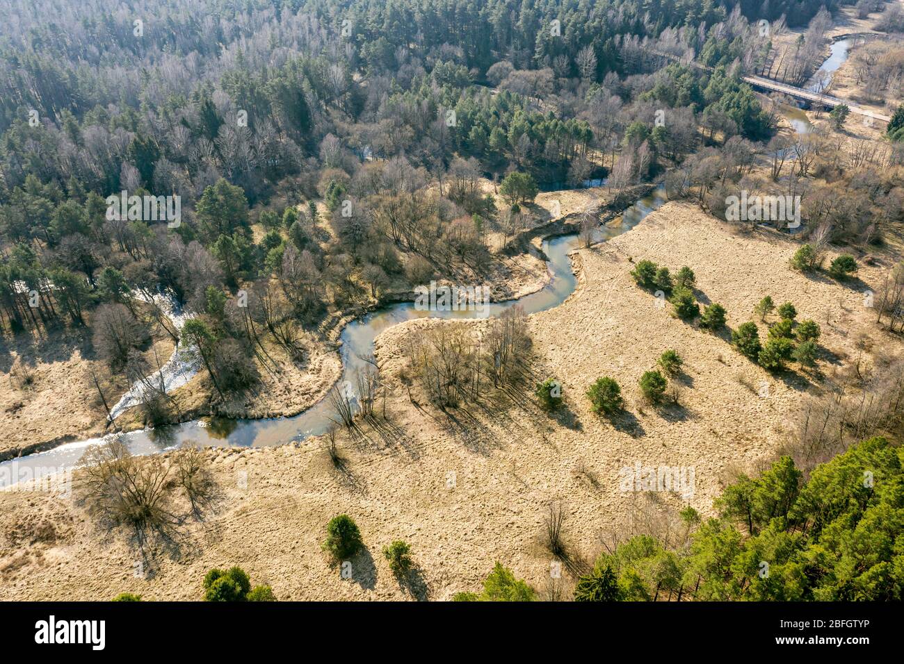 Frühlingslandschaft aus Wald und kleinen gewundenen Fluss. Luftdrohne Foto Stockfoto