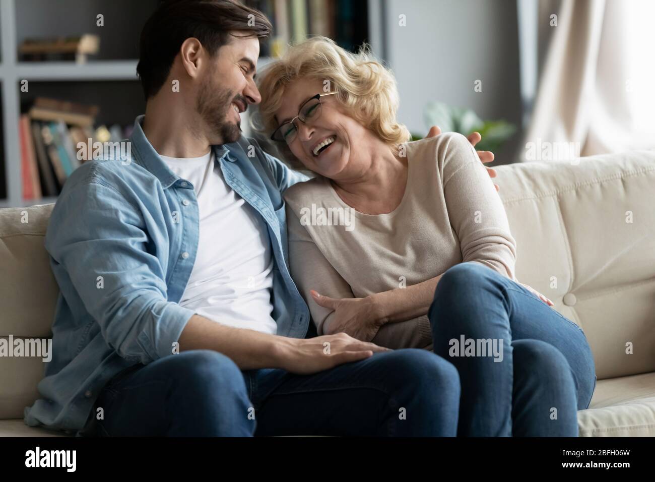 Fröhlich reife Mutter genießen Kommunikation lacht Gespräche mit erwachsenen Sohn Stockfoto