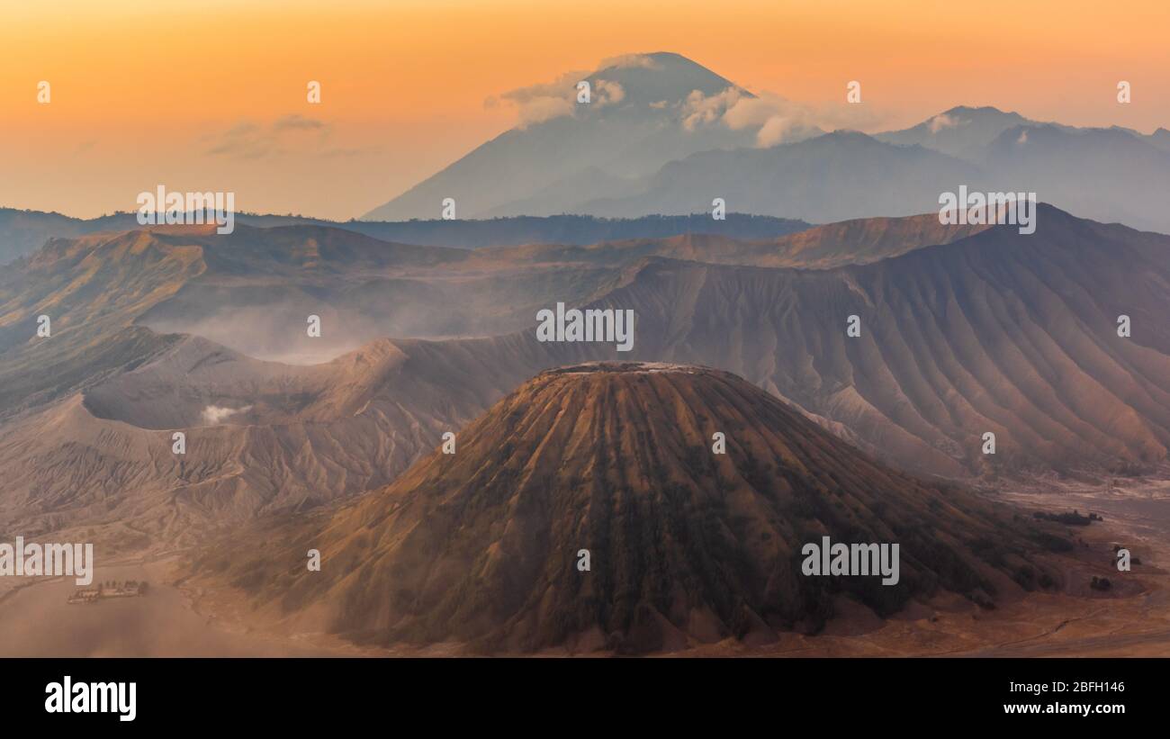 Sonnenaufgang über dem Mount Bromo und Semeru Vulkan Komplex an einem roten, staubigen Morgen gibt der Landschaft ein rotes, marsianisches Aussehen Stockfoto