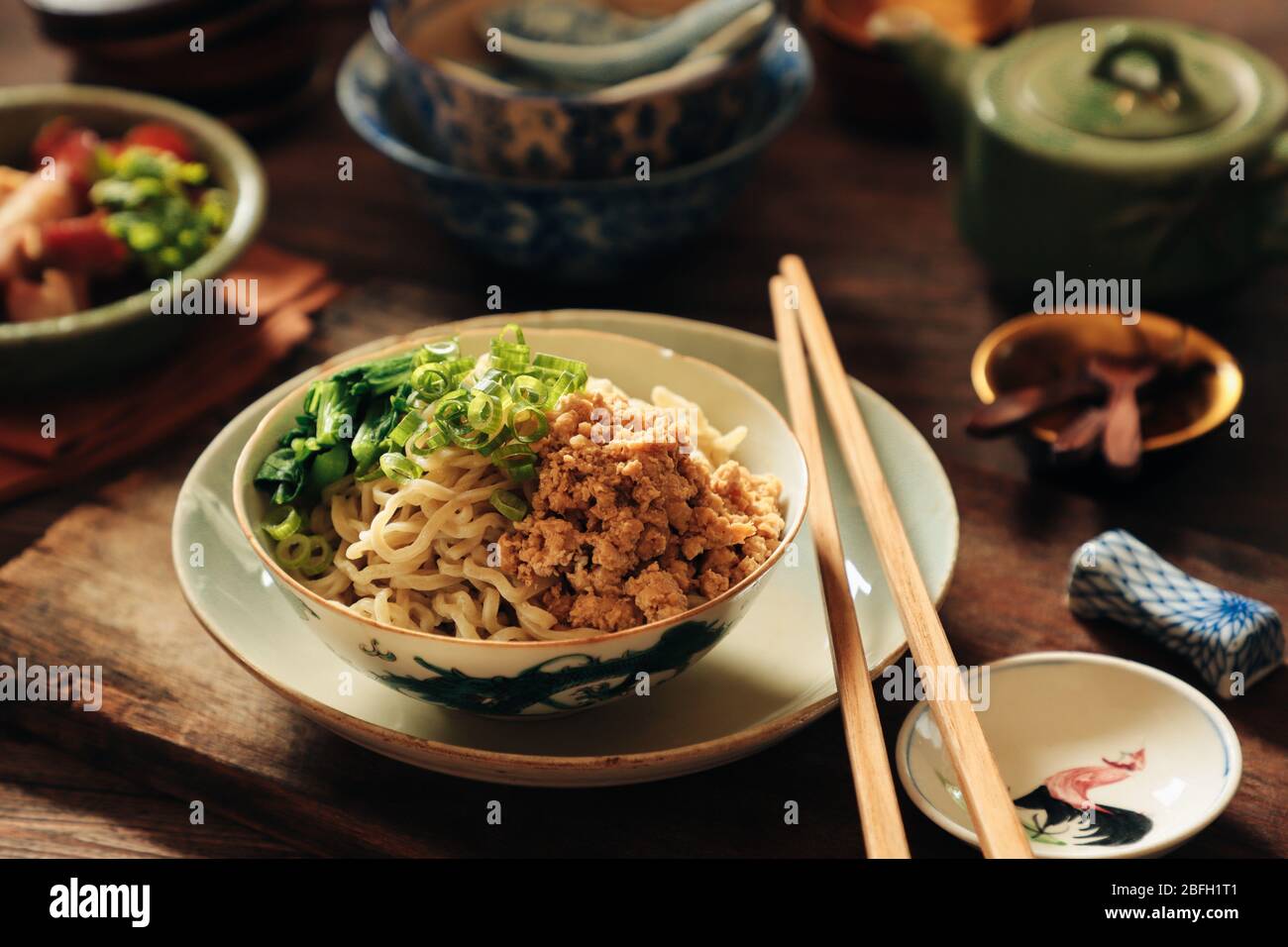 Ei Noodles mit gehacktem Huhn. Ein chinesisches Grundnahrungsmittel aus gelben Nudeln mit Soja-gewürztem Hackfleisch und Choy Sum; auf Vintage-Geschirr überzogen. Stockfoto
