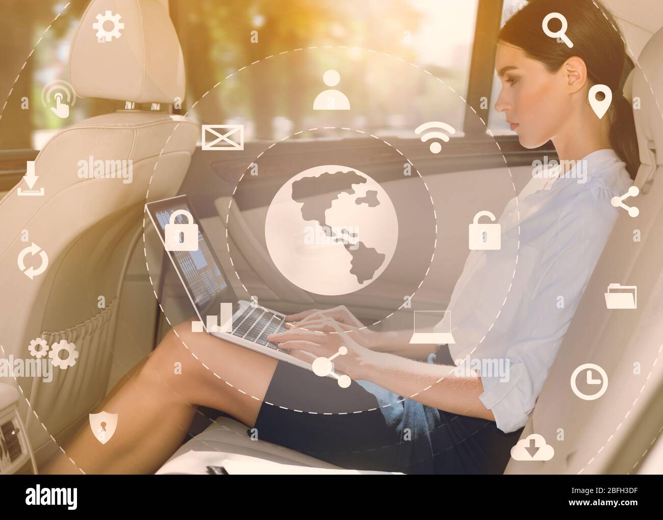 Geschäftsfrau mit Laptop in Rücksitz des Luxuswagens Stockfoto