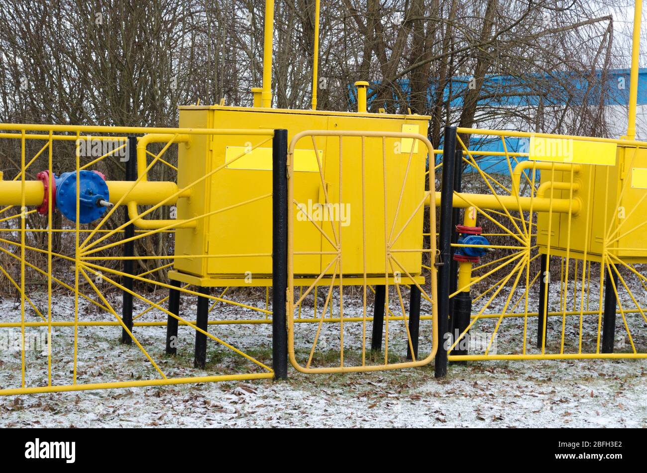 Gelbe Gasverteilerstation. Die Gasleitung ist gelb mit zusätzlicher Ausrüstung, Rohren und einem Ventil. Stockfoto