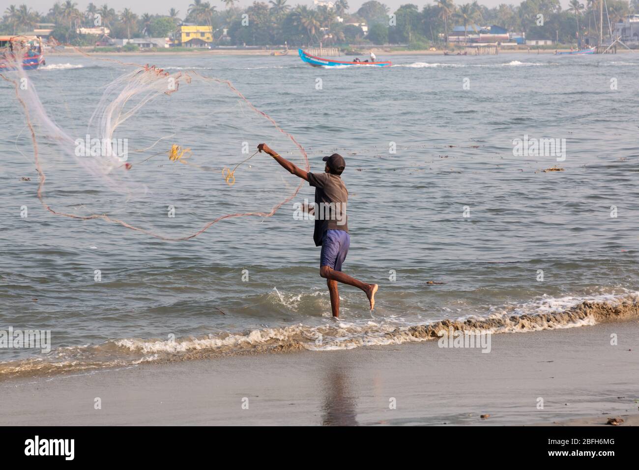 Kochi, Kerala - 30. Dezember 2019: Fischer, der sein Netz vom Strand von kochi, kerala indien auswirft Stockfoto