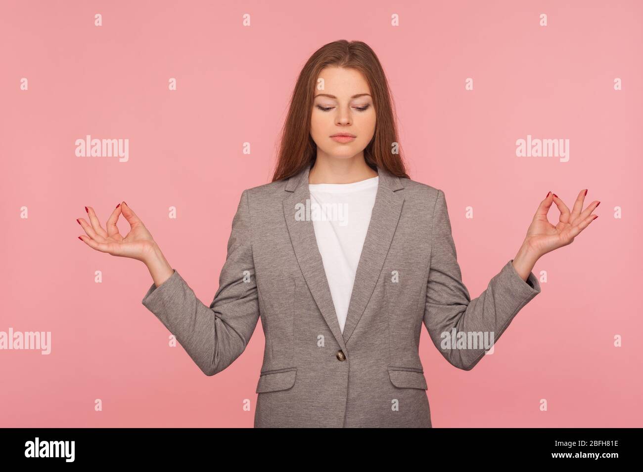 Gedankenkontrolle, Yoga-Praxis. Porträt einer jungen Frau im Business-Anzug meditieren mit namaste Geste, suchen ruhig befriedigt, Entspannung und Harmonie. Stockfoto