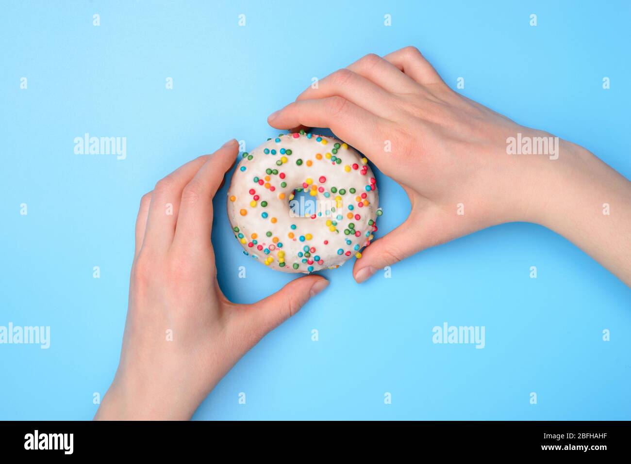 Top über flach legen Flatlay Overhead Nahaufnahme Foto von Händen nehmen Kauf leckere frische zuckerhaltige Donut bereit, um über Pastell-Farbe Tisch isoliert essen Stockfoto