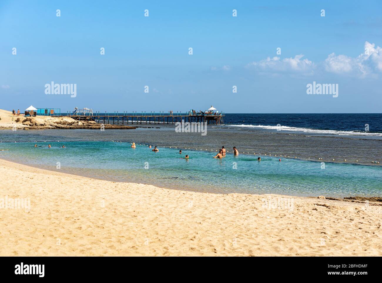 Wunderschöner Sandstrand und Meerlandschaft mit einem Pier über dem Korallenriff, wo man tauchen oder schnorcheln kann. Rotes Meer bei Marsa Alam, Ägypten, Afrika Stockfoto