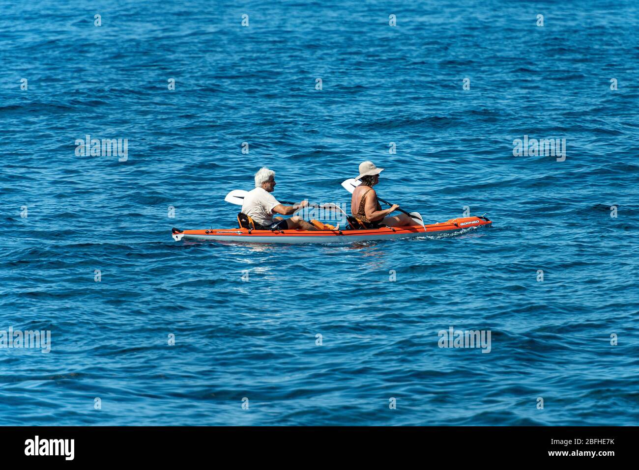 Reifes Paar an Bord eines orangefarbenen Kayaks, paddeln im blauen Mittelmeer, Golf von La Spezia, Ligurien, Italien, Europa Stockfoto