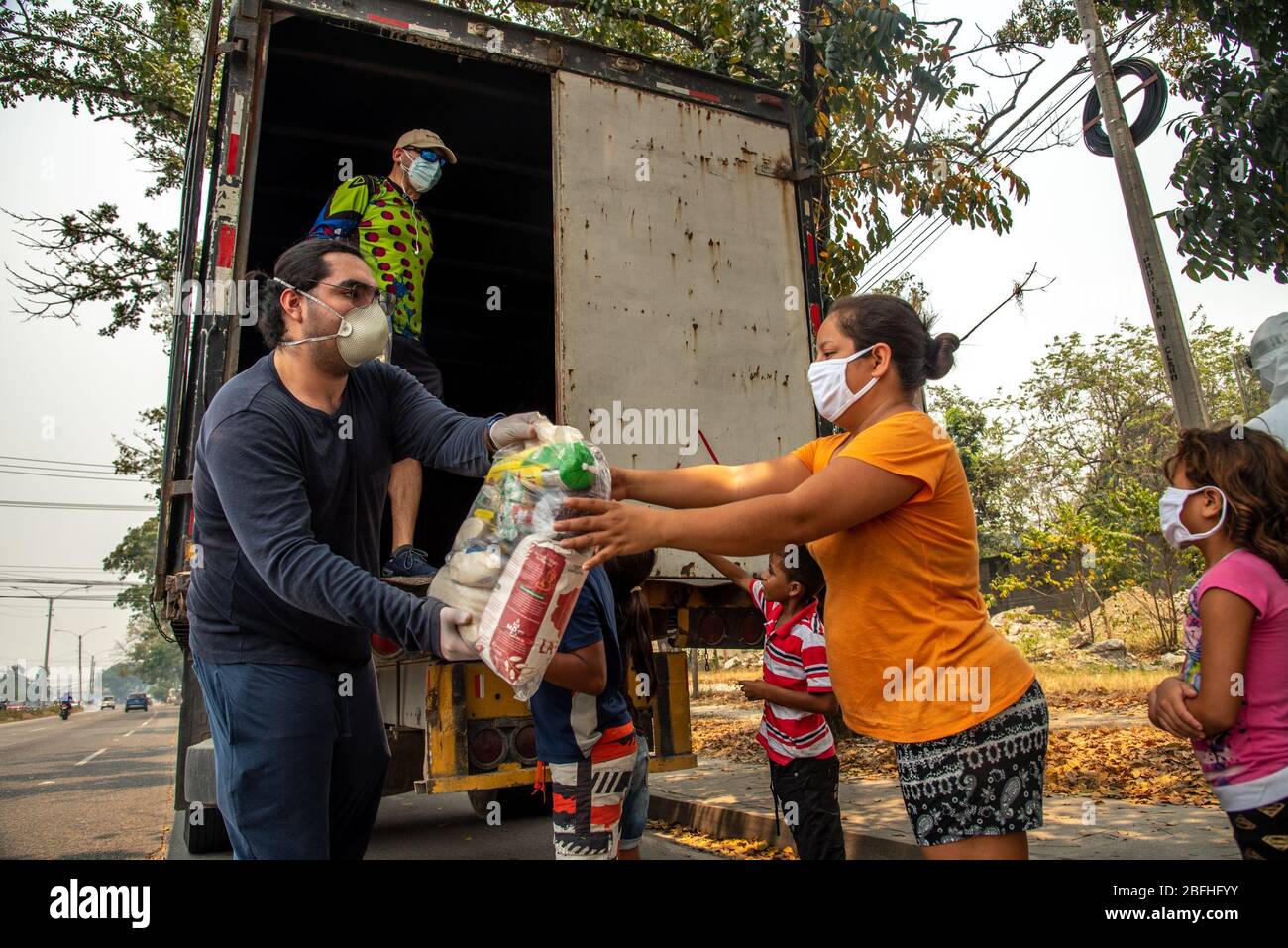 Lokale Wohltätigkeitsorganisationen verteilen während der Sperrung des Coronvirus Beutel mit lebensnotwendigen Lebensmitteln an die gefährdeten Menschen.über 60% der Menschen in Honduras leben in Armut. Während der Sperrung des Coronavirus haben die am stärksten gefährdeten Menschen die größten negativen Auswirkungen gesehen. Überall in der Stadt sind Menschen aus den ärmsten Vierteln auf die Straße geströmt, um um Hilfe zu bitten. Oft konnte die Regierung nicht die notwendige Hilfe leisten. Hier sammelte eine Gruppe von Einheimischen Geld, kaufte Lebensmittel und organisierte alle Logistik, Polizei sorgte für Sicherheit, aber an ihrem letzten Halt wurden Menschen leer gelassen beca Stockfoto