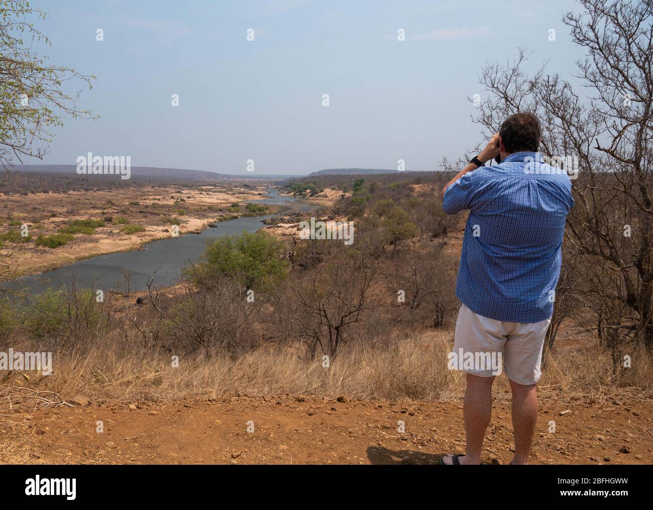 Ein Mann, der durch ein Fernglas auf einen der Aussichtstellen Krugers schaut Stockfoto