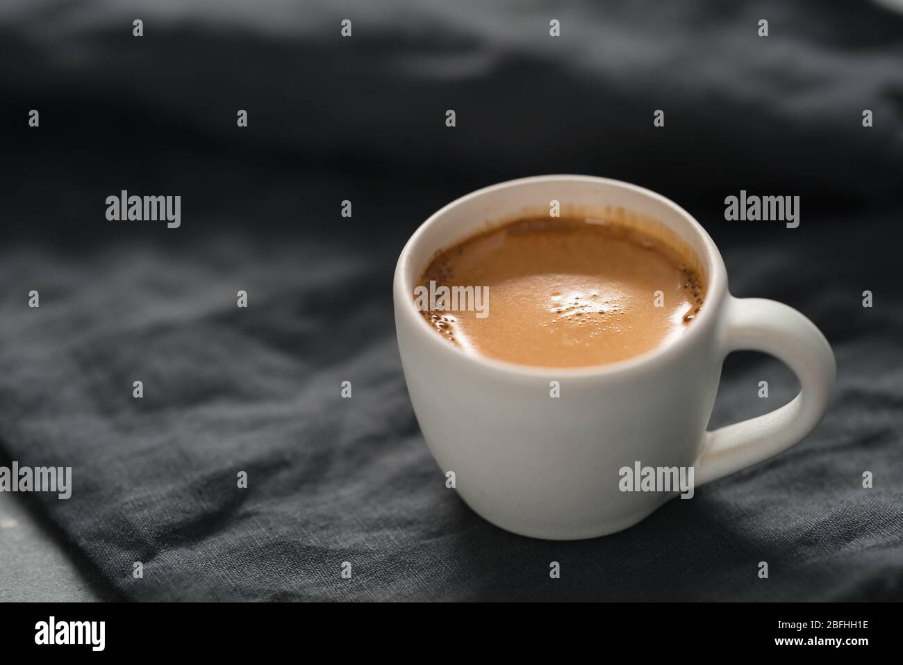 Heißer Espresso in weißer Tasse auf Leinentuch mit Kopie Platz Stockfoto