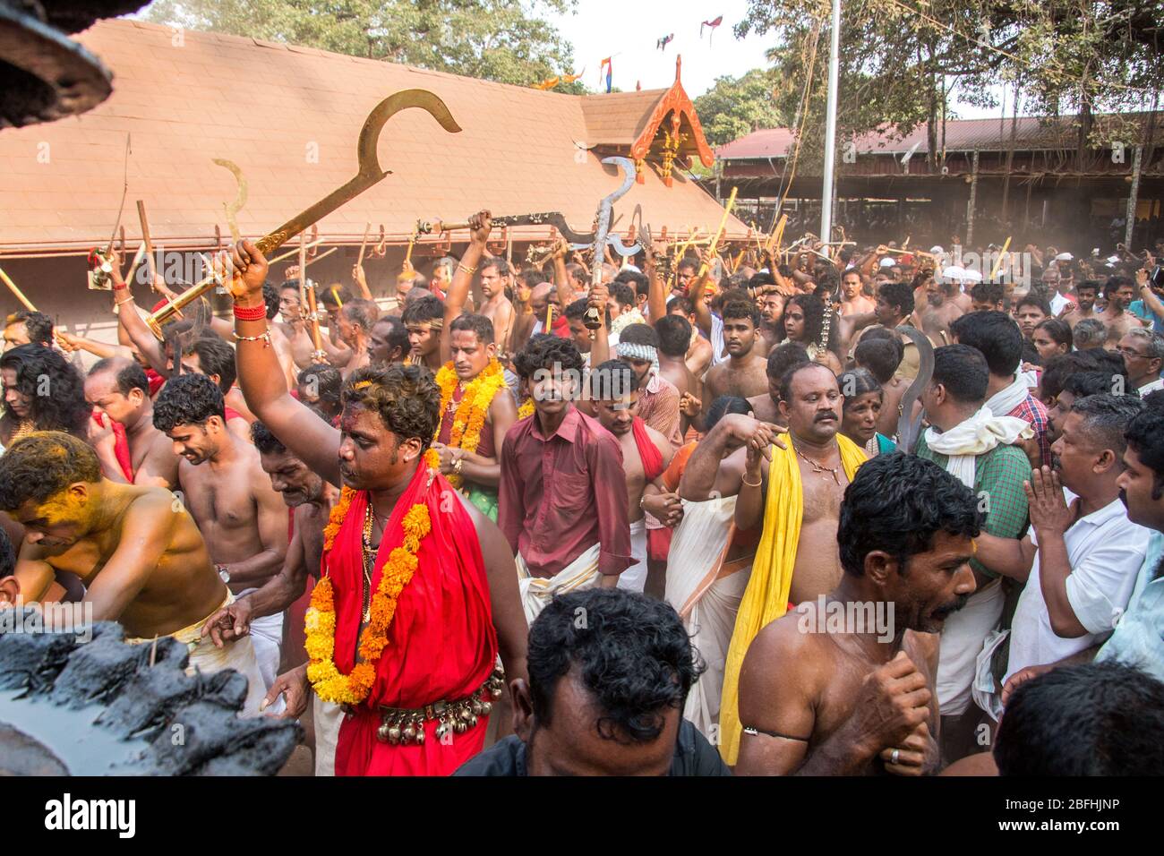 Anhänger im roten Kleid und Sickleshaped Schwerter am Sree Kurumba Sree Kurumba Bhagwati Tempel Kodungallur, während Bharani Festival, Thrissur, Kerala, Indien Stockfoto