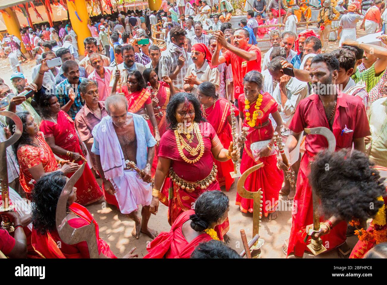 Anhänger im roten Kleid und Sickleshaped Schwerter am Sree Kurumba Sree Kurumba Bhagwati Tempel Kodungallur, während Bharani Festival, Thrissur, Kerala, Indien Stockfoto