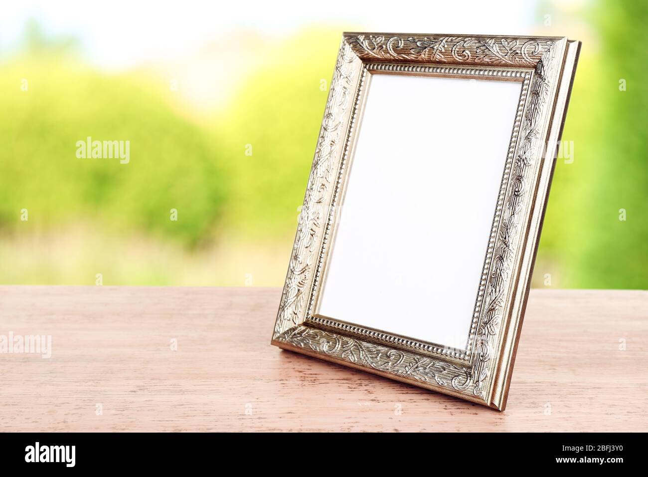 Bilderrahmen auf Holztisch auf Naturhintergrund Stockfoto