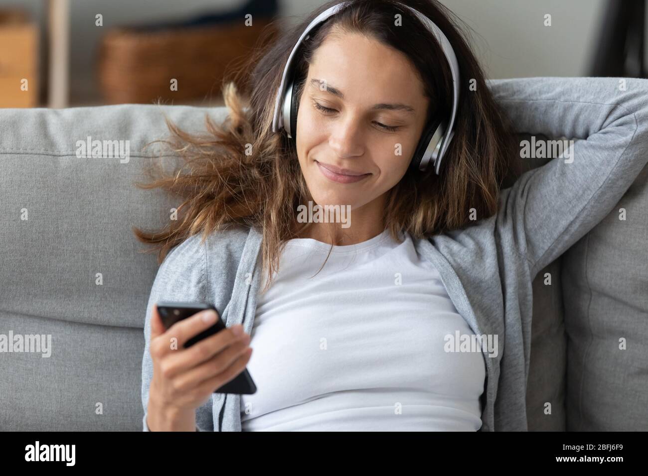 Schöne Frau in Kopfhörer mit Telefon, Musik hören Stockfoto