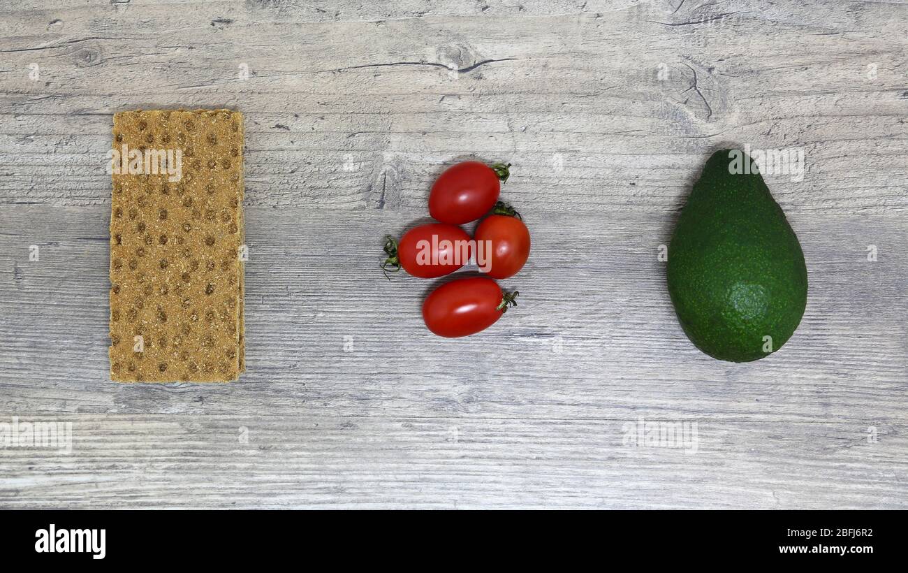 Essen, Frühstück, Sandwich. Tomaten, Avocado, Brot, Toast. Zutaten, kochen. Vegan, vegetarisch, richtige Ernährung. Stockfoto