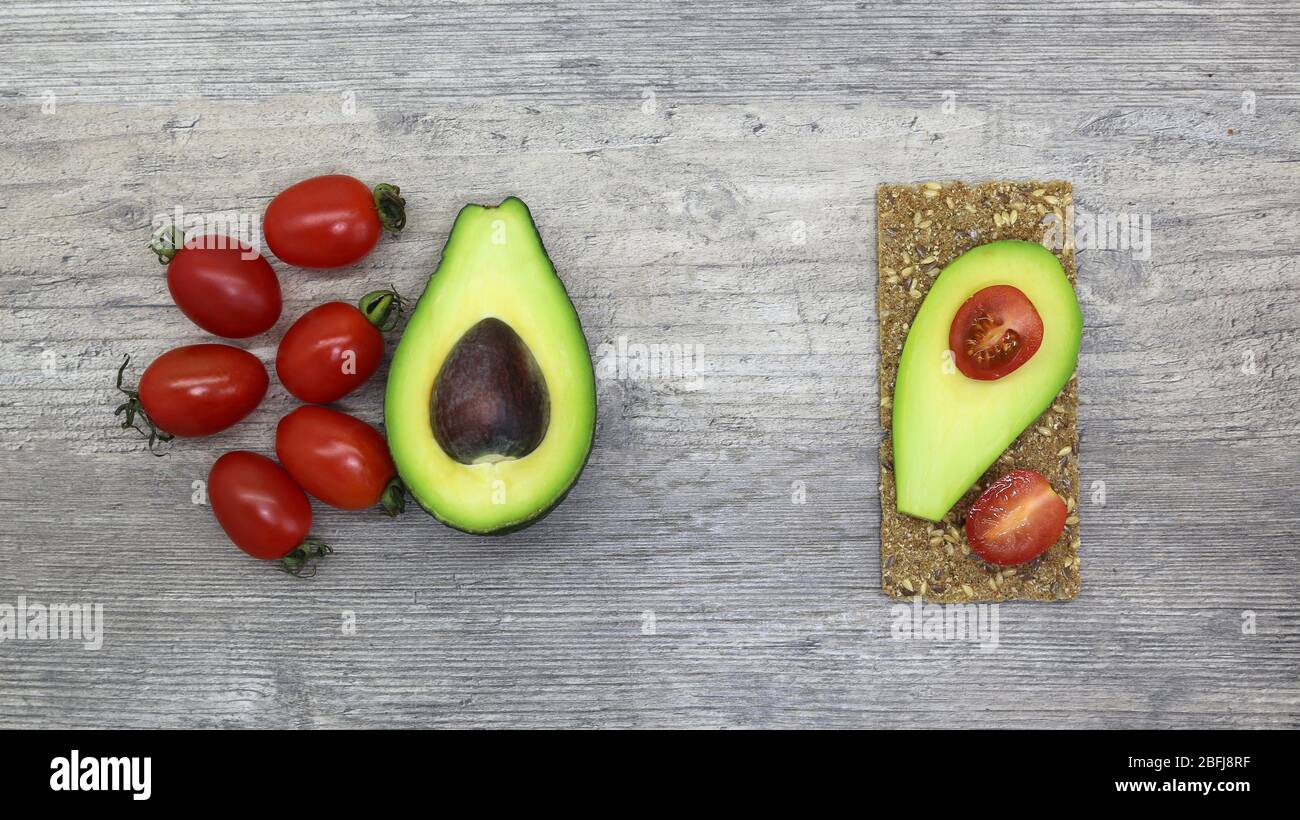 Essen, Frühstück, Sandwich. Tomaten, Avocado, Brot, Toast. Zutaten, kochen. Vegan, vegetarisch, richtige Ernährung. Stockfoto