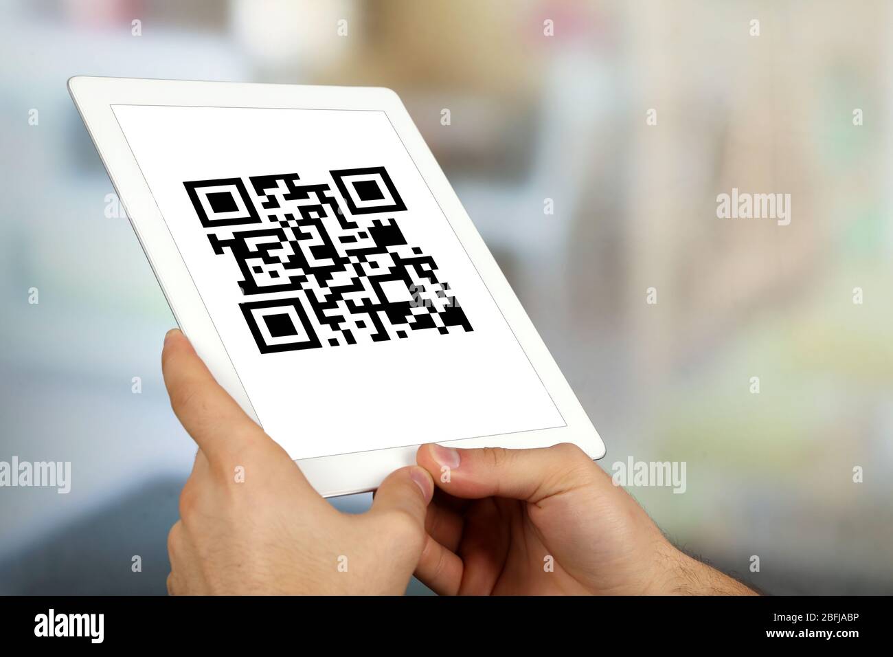 Hand-Tablet mit QR-Code auf dem Bildschirm Stockfoto