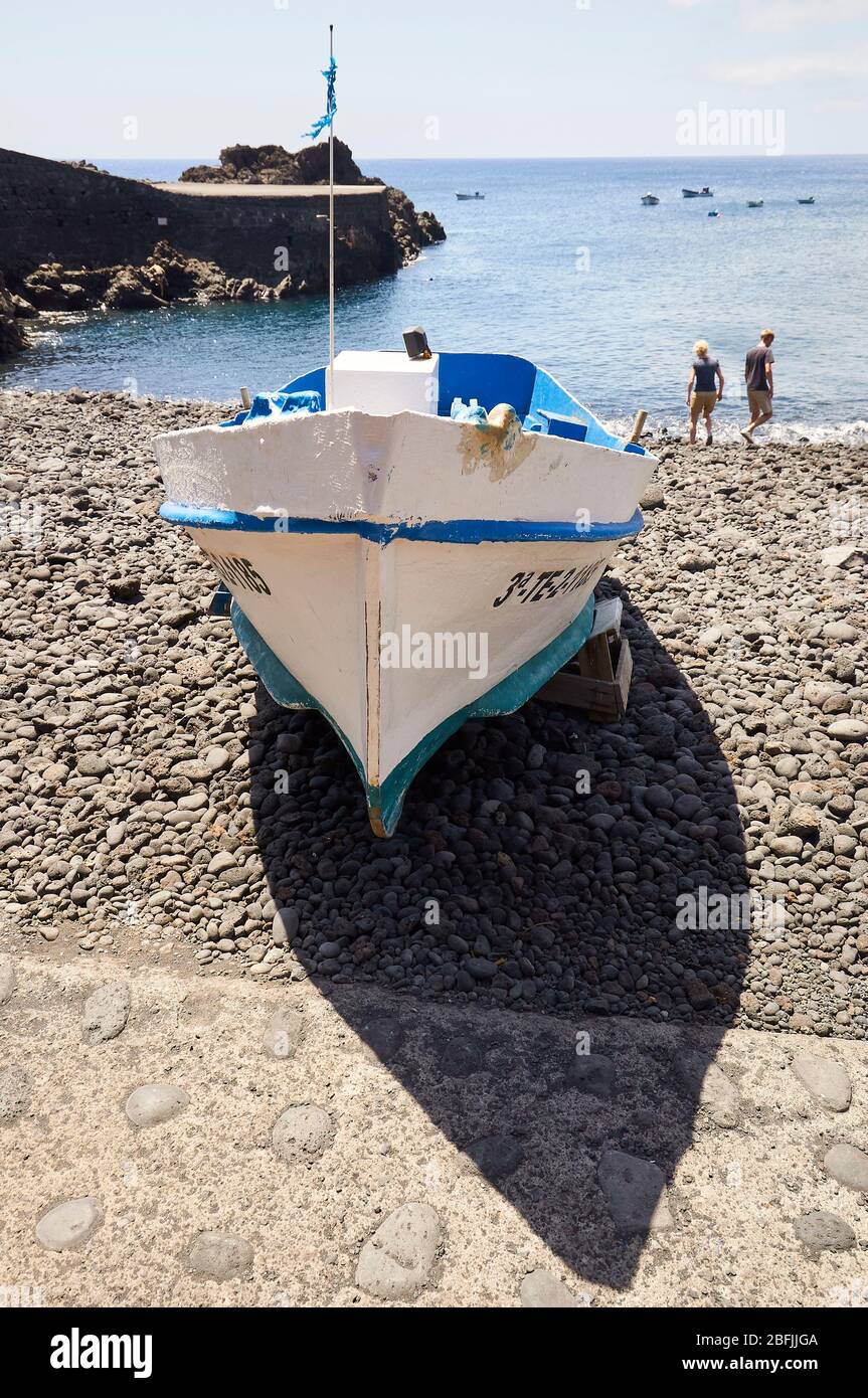 Traditionelles Fischerboot, das am Strand Playa del Faro de Fuencaliente gestrandet ist und Touristen im Hintergrund (La Palma, Kanarische Inseln, Atlantik, Spanien) Stockfoto