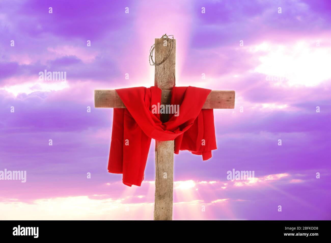 Kreuz mit Dornenkrone und rotem Tuch auf Himmel Hintergrund Stockfoto