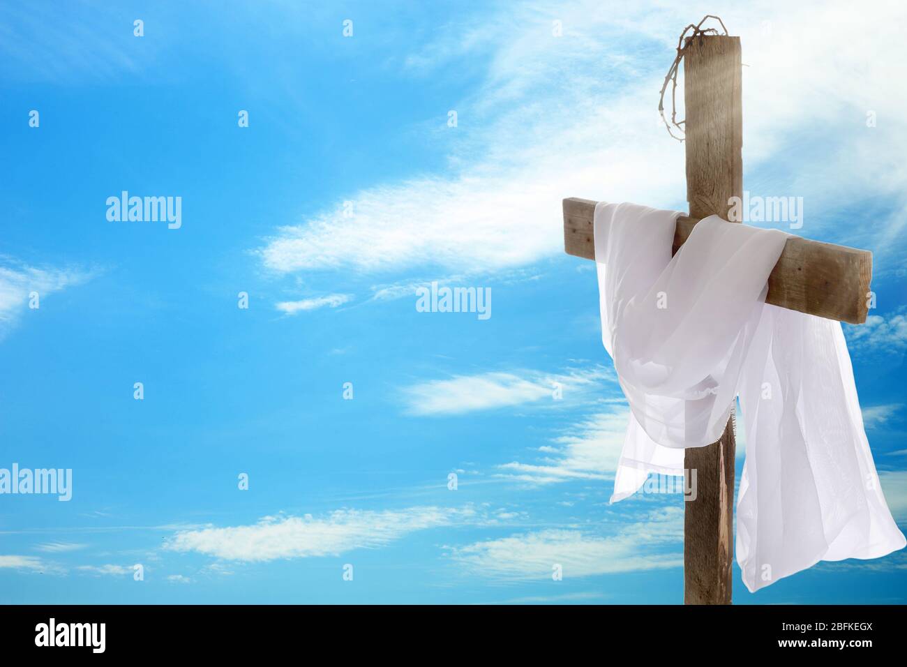 Kreuz mit Dornenkrone und Tuch auf Himmel Hintergrund Stockfoto