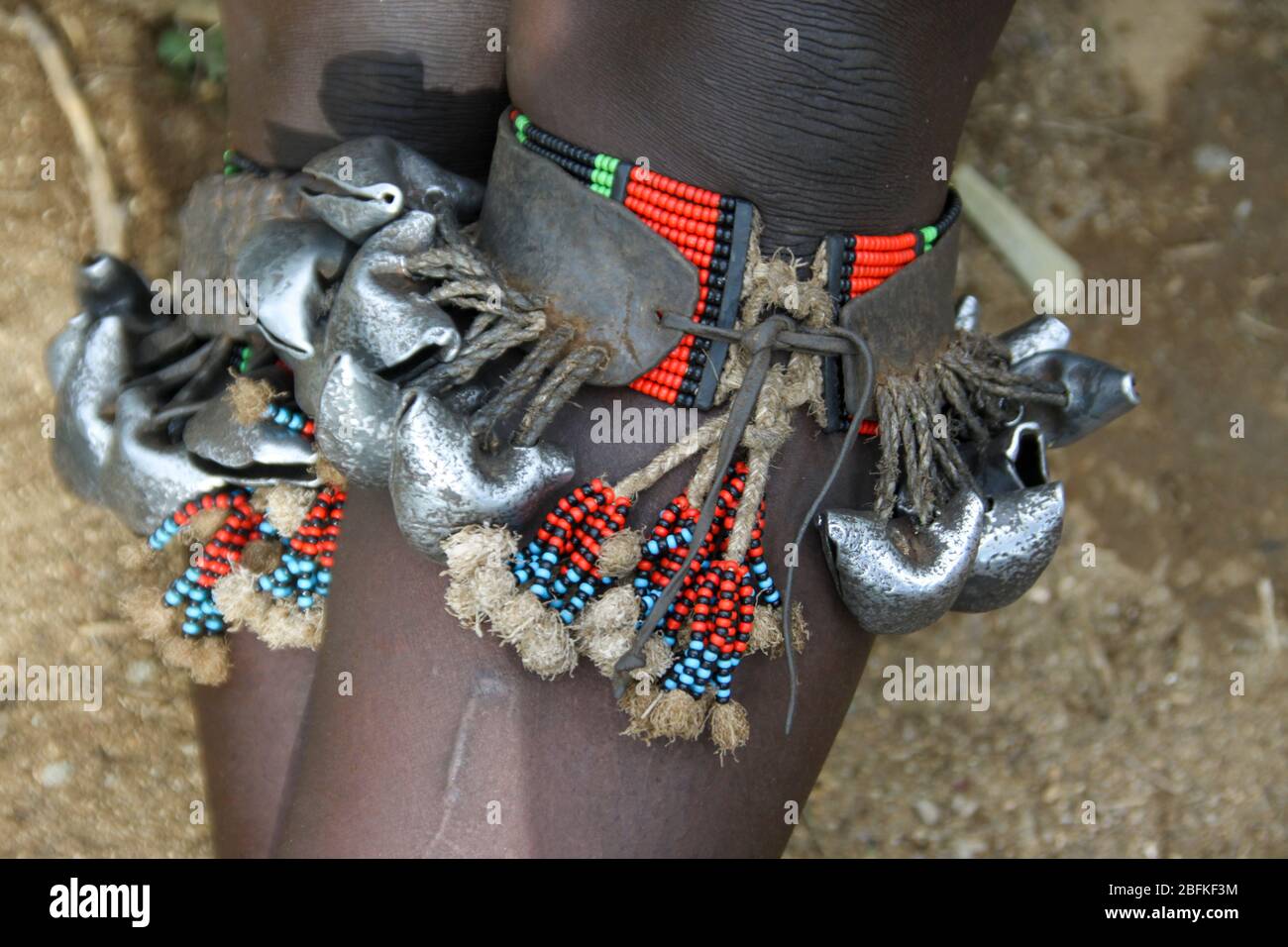 Eine Hamar-Frau trägt Glocken an ihren Unterschenkeln, um beim Tanzen Klang zu erzeugen. Fotografiert im Omo River Valley, Äthiopien Stockfoto