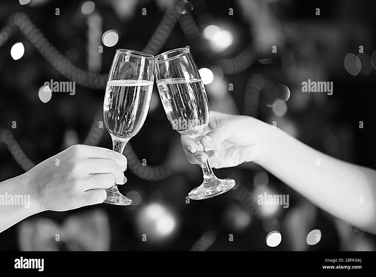 Anklirrender Champagner in den Händen, schwarz-weiß Retro-Stilisierung Stockfoto