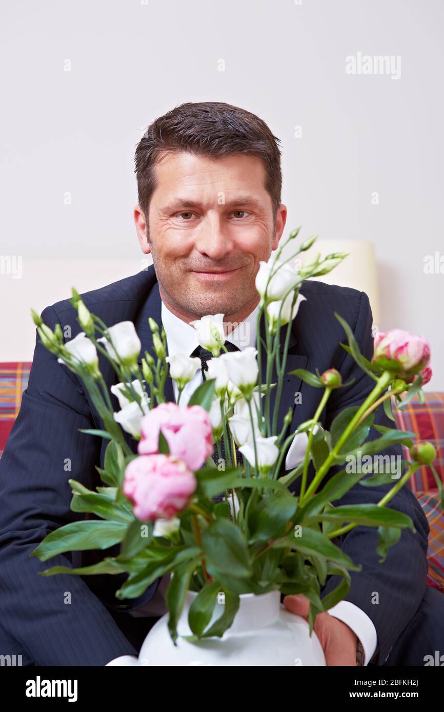 Lächelnder Geschäftsmann mit einem Strauß voller Rosen Stockfoto