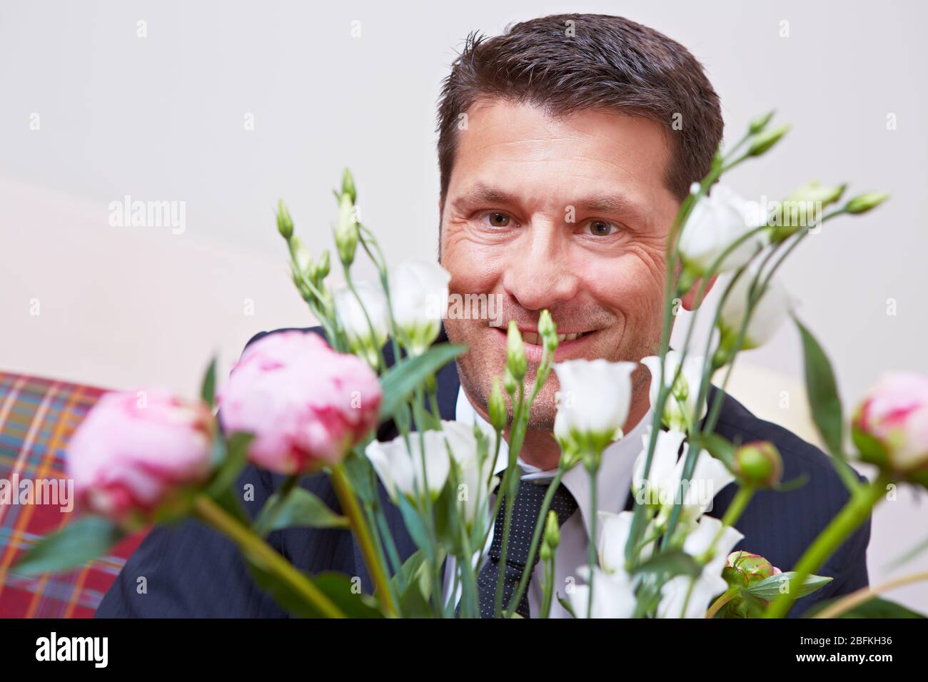 Happy Manager mit einem Strauß weißer und rosa Rosen Stockfoto