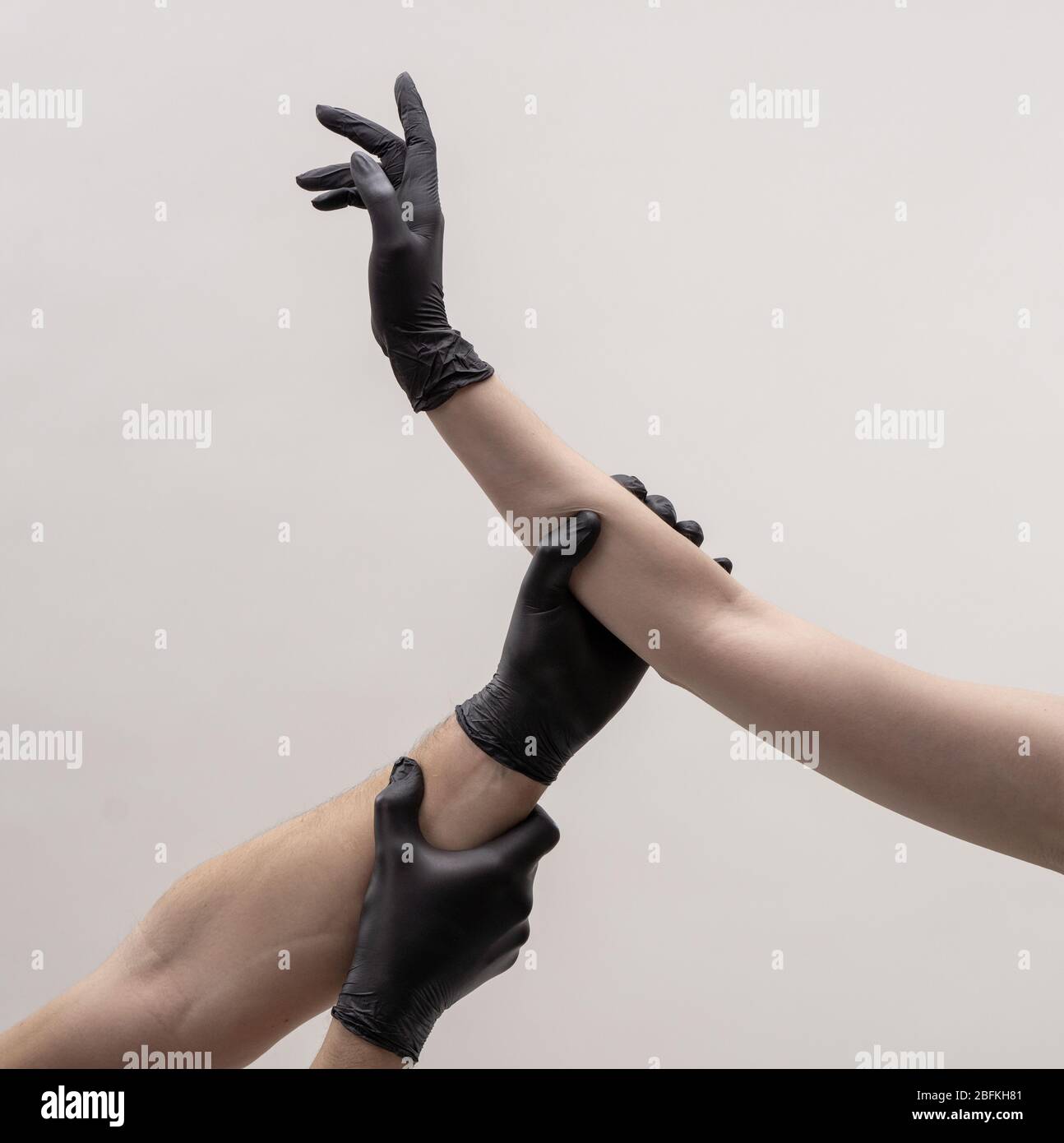 Männliche und weibliche Hand in schwarzen Handschuhen. Halten Sie sich gegenseitig. Stockfoto