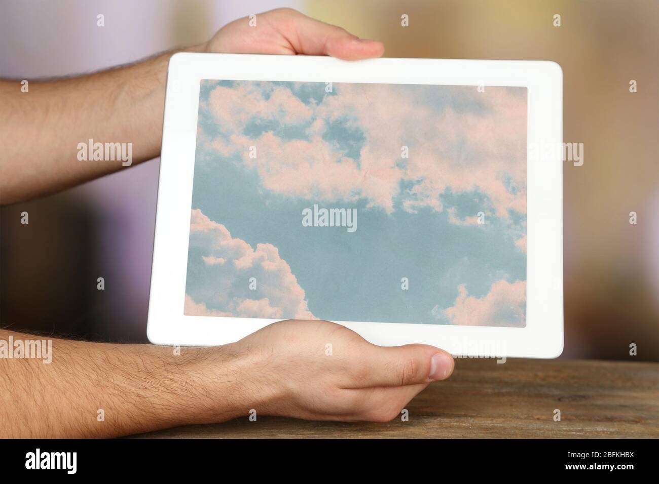 Hände halten Tablet PC mit Himmel im Bildschirm. Cloud Computing-Konzept Stockfoto