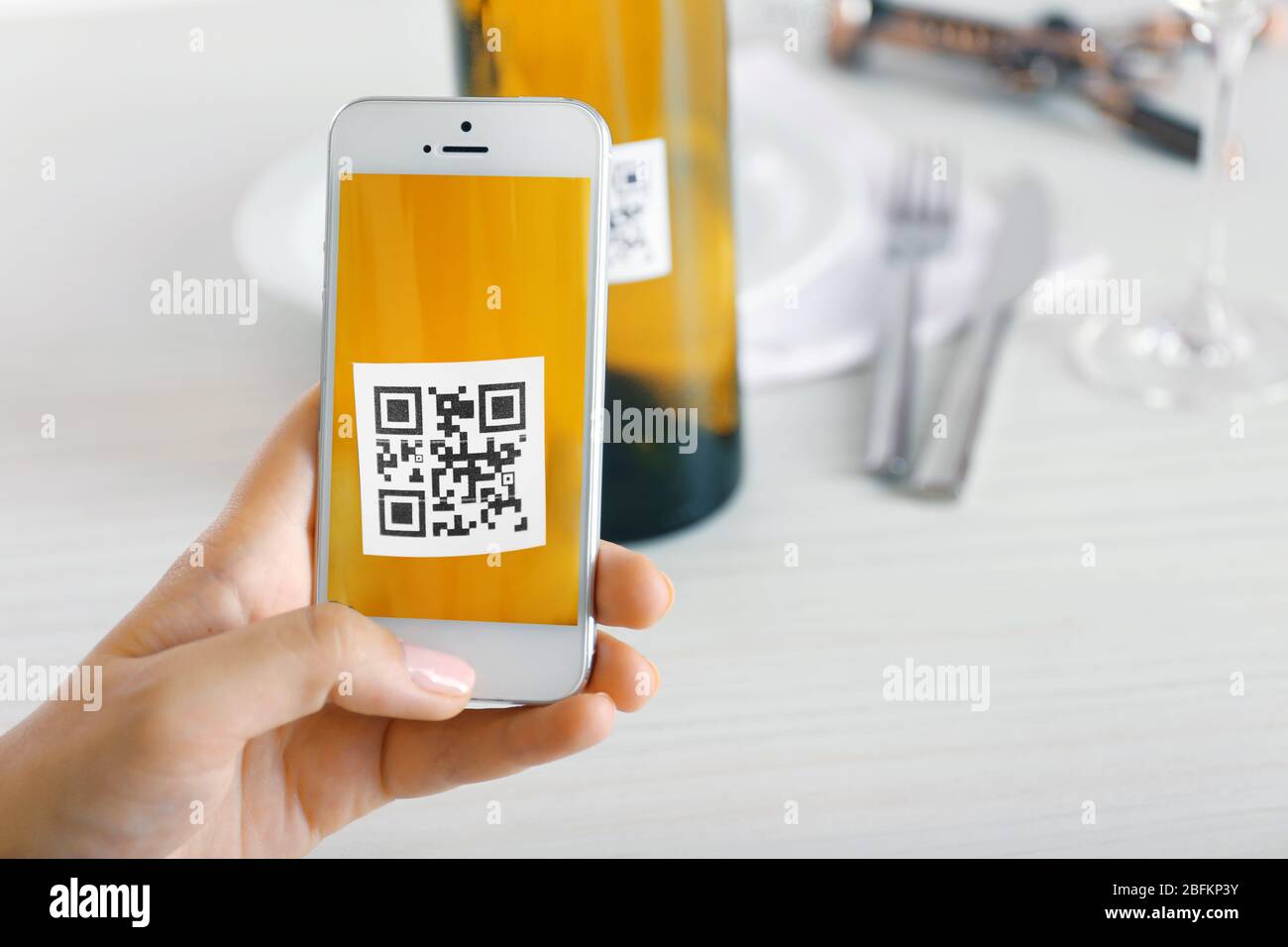 Frau scannt Gutschein-Code mit Handy aus nächster Nähe Stockfoto