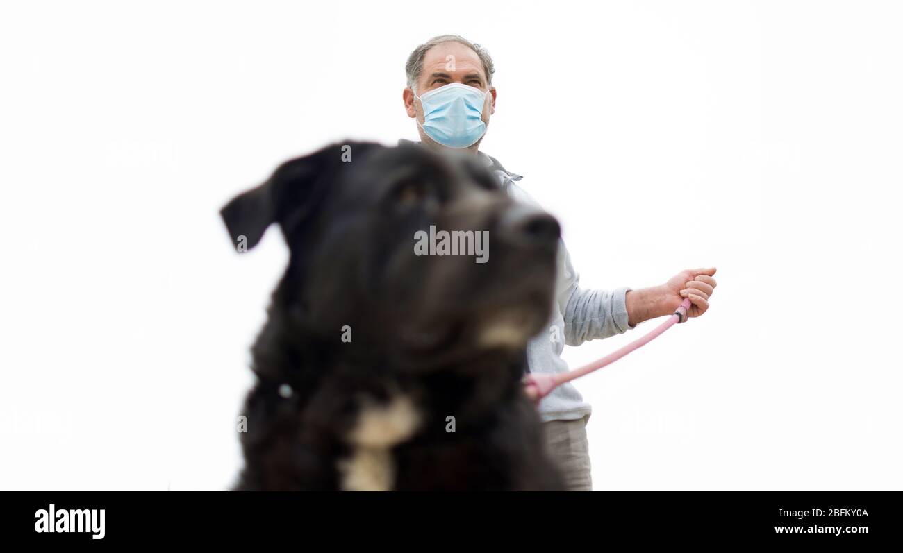 Ein Mann geht mit seinem Hund nach draußen, nachdem Spanien eine Sperre auferlegt hatte, um die Ausbreitung der Coronavirus-Krankheit in Murcia, Spanien, 19. April 2020, zu verlangsamen Stockfoto