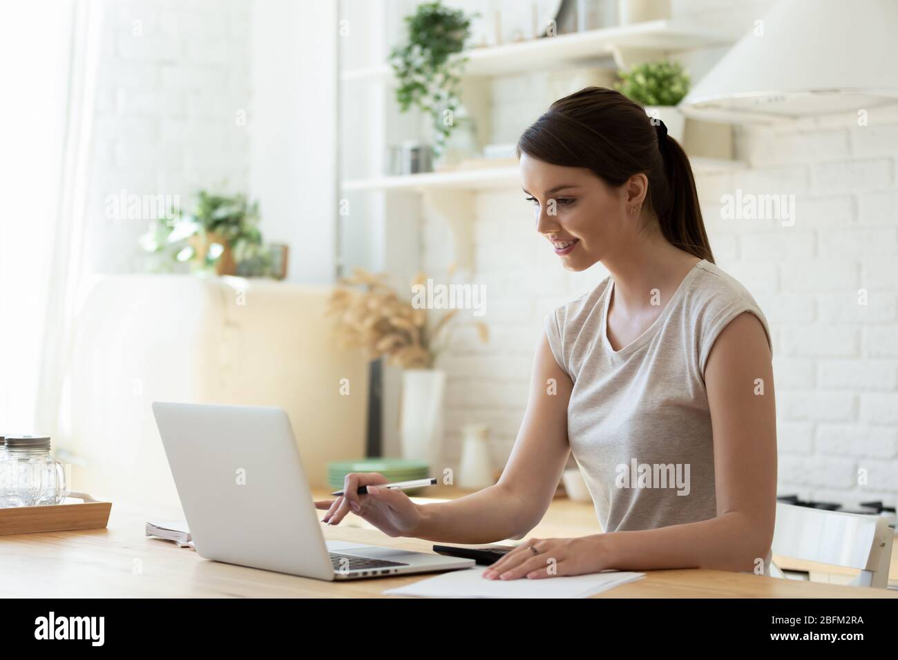 Glückliche junge attraktive Frau mit Rechner und Laptop für die Berechnung. Stockfoto
