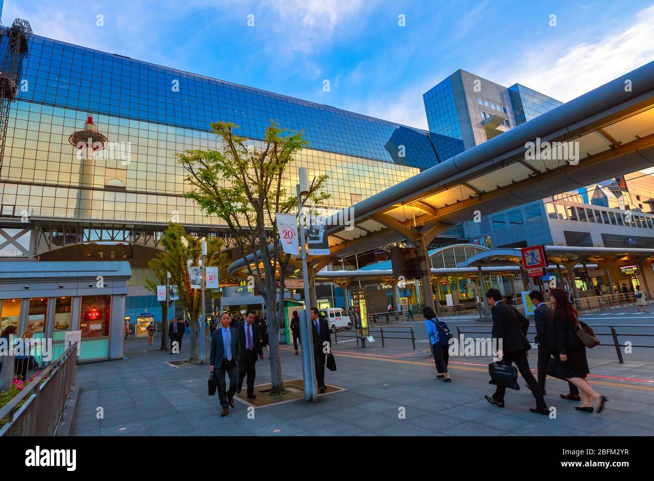 Kyoto, Japan - 27. April 2017: asiatische Menschen und Pendler am Bahnhof Kyoto. Kyoto Tower mit Aussichtsplattform, spiegelt sich auf der Glasfassade des Bahnhofs Stockfoto
